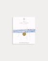 Early Sunday, Charm Bracelet in Tonal Floral Blue color, made from Printed Cotton Tiny Swiss Dobby fabric, featuring a soft fabric bracelet design with a charm, shown in a front flat-lay view