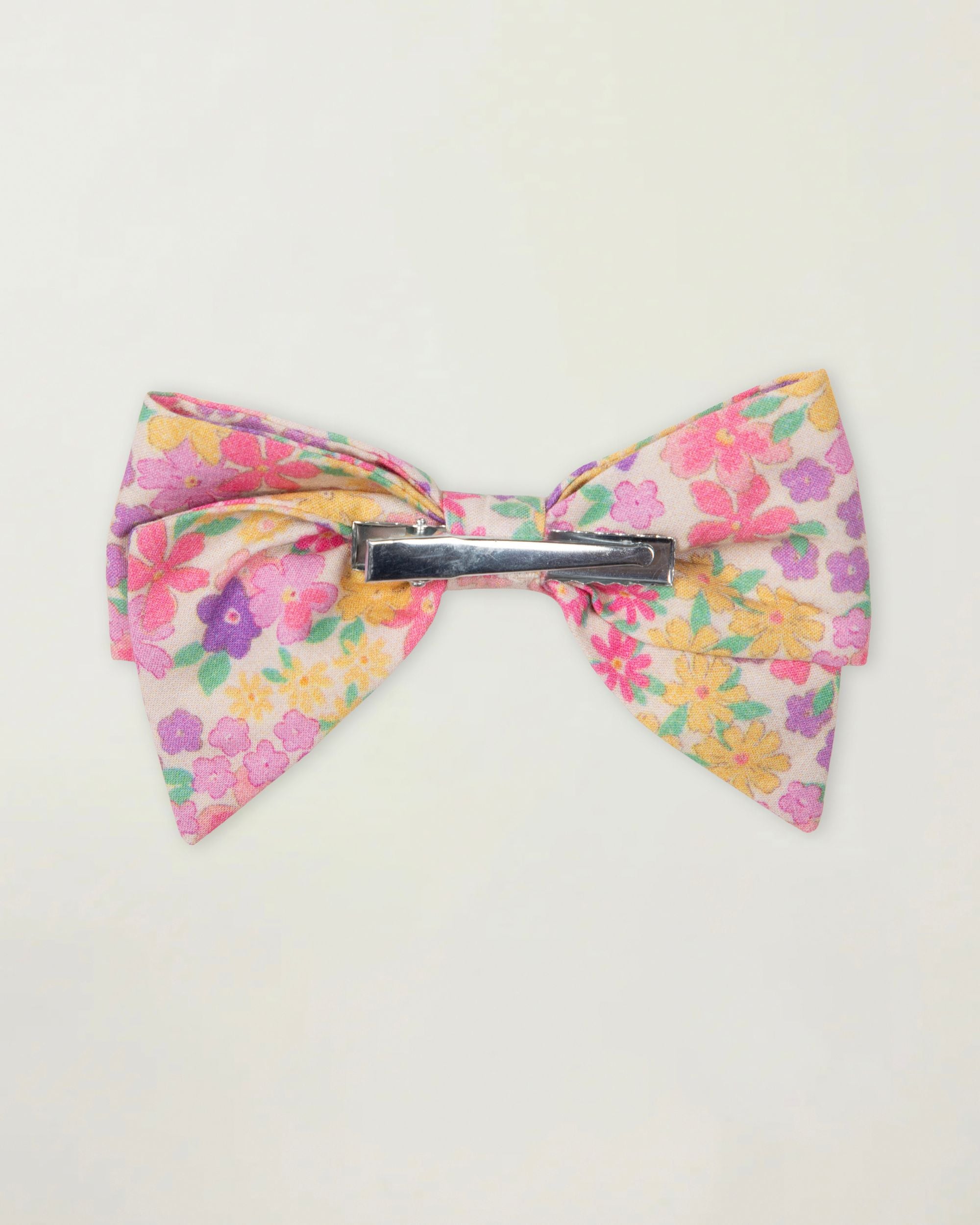 Early Sunday, Chiara Clip in Emma Floral Purple color, made from Organic Printed Cotton Cambric fabric, featuring a bow design on an alligator clip with a secure fit, shown in back flat-lay view