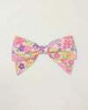 Early Sunday, Chiara Clip in Emma Floral Purple color, made from Organic Printed Cotton Cambric fabric, featuring a bow design on an alligator clip with a secure fit, shown in front flat-lay view