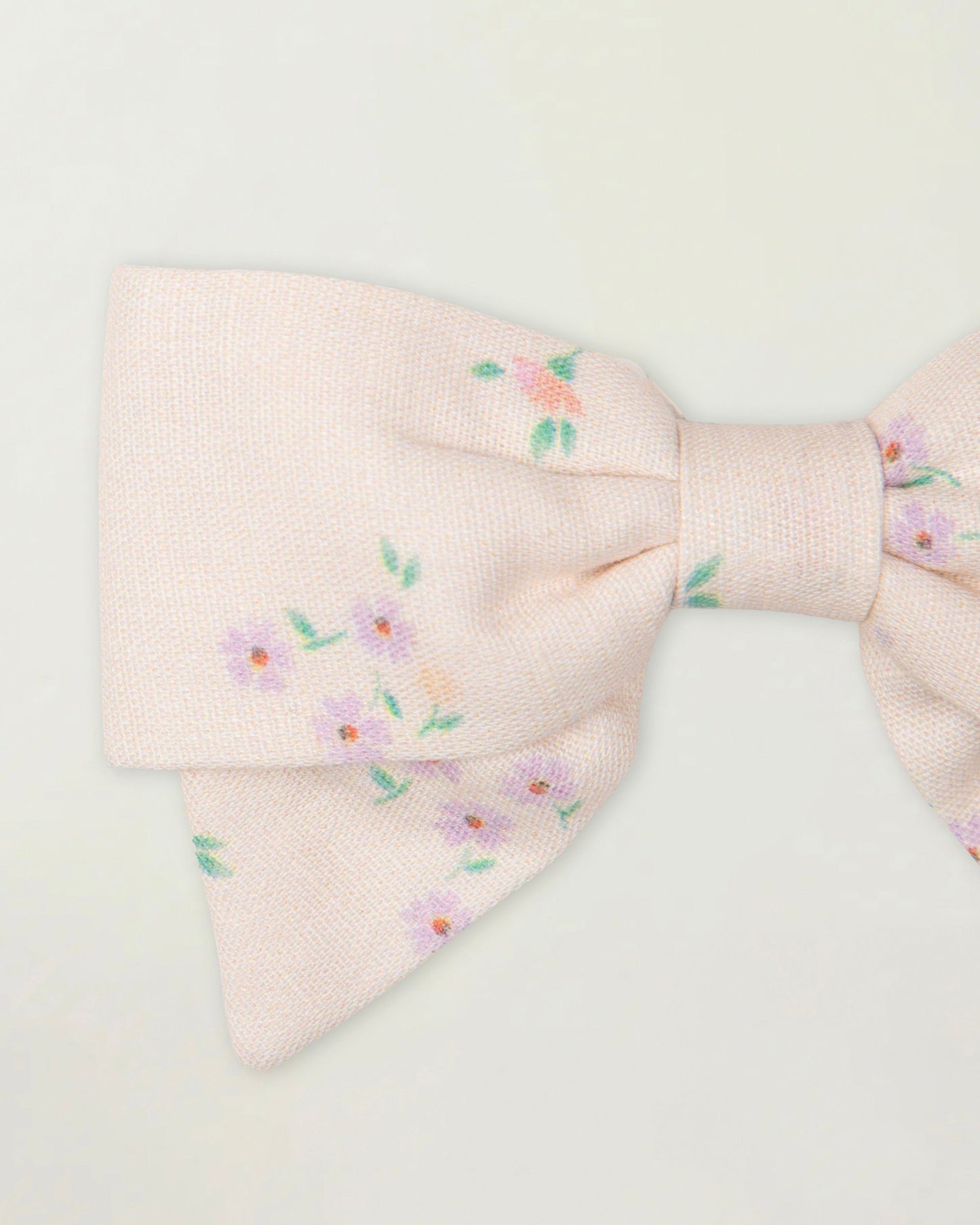 Early Sunday, Chiara Clip in Painted Bouquet print, made from Printed 70% Cotton, 30% Linen fabric, featuring a bow design on an alligator clip with a secure fit, shown in a closeup flat-lay view