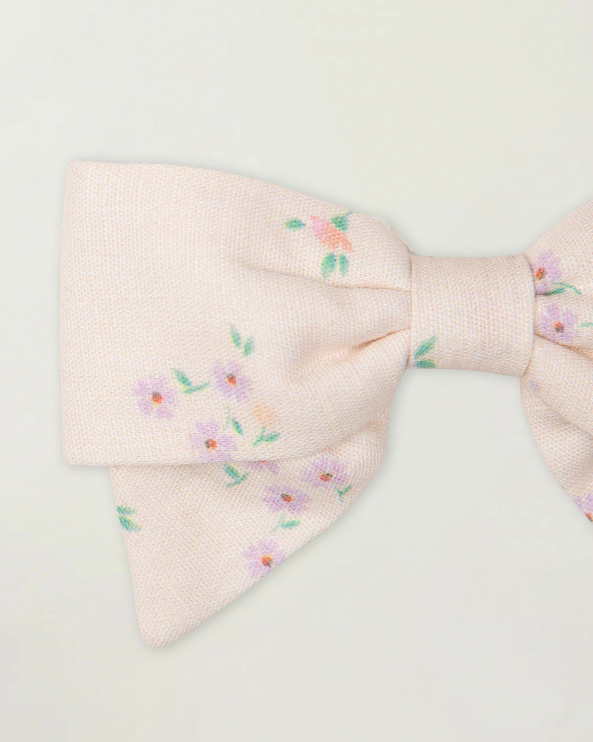 Early Sunday, Chiara Clip in Painted Bouquet print, made from Printed 70% Cotton, 30% Linen fabric, featuring a bow design on an alligator clip with a secure fit, shown in a closeup flat-lay view