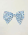 Early Sunday, Chiara Clip in Tonal Floral Blue color, made from Printed Cotton Tiny Swiss Dobby fabric, featuring a bow design on an alligator clip with a secure fit, shown in a front flat-lay view