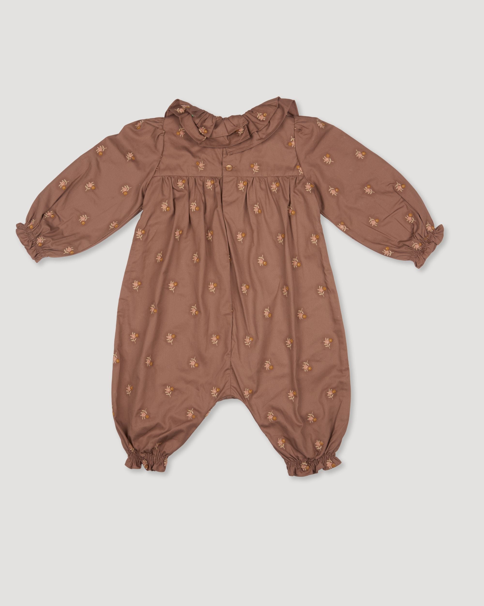 Early Sunday, Coco Baby Romper in Bark color, made from All-over Embroidered 30s Cotton Brushed Twill fabric, featuring ruffled neckline with leaf prints, shown in a back flat-lay view