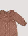 Early Sunday, Coco Baby Romper in Bark color, made from All-over Embroidered 30s Cotton Brushed Twill fabric, featuring ruffled neckline with leaf prints, shown in a closeup flat-lay view