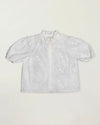 Early Sunday, Coco Blouse in Ivory color, made from all over embroidery fabric, featuring Puff sleeves, ruffled neckline and placket, shown in a front flat-lay view