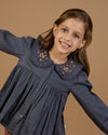 Early Sunday, Colette Blouse in Stormy Blue, made from Cotton Satin fabric, featuring relaxed fit, classic collar, and button-down front, shown in a close-up side view of a model wearing it
