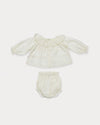 Early Sunday, Daisy Baby Blouse & Bloomer Set in Ivory, made from Cotton Dobby Spot fabric, featuring a blouse with frilly neckline & gathered sleeves, shown in a back flat-lay view
