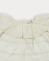 Early Sunday, Daisy Baby Blouse & Bloomer Set in Ivory, made from Cotton Dobby Spot fabric, featuring a frilly neckline with detailed lace yoke & gathered sleeves, shown in a closeup flat-lay view