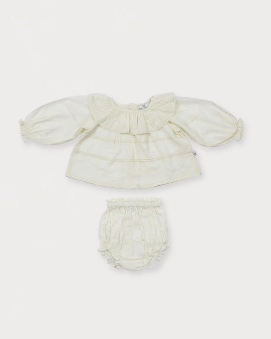 Early Sunday, Daisy Baby Blouse & Bloomer Set in Ivory, made from Cotton Dobby Spot fabric, featuring a frilly neckline & detailed lace yoke with matching bloomer, shown in a front flat-lay view