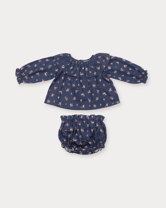 Early Sunday, Daisy Baby Blouse & Bloomer Set in Ditsy Bouquet Navy, made from Printed Cotton Satin fabric, featuring a frilly neckline with detailed lace yoke & gathered sleeves, shown in a front flat-lay view