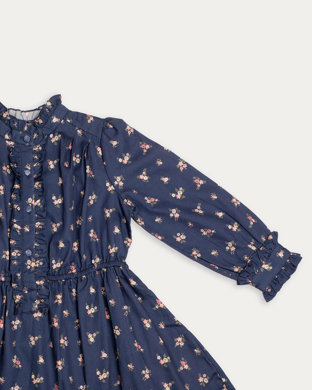 Early Sunday, Dawn Dress in Ditsy Bouquet Navy, made from Printed Cotton Satin fabric, featuring a soft flowing hem, shown in a closeup flat-lay view