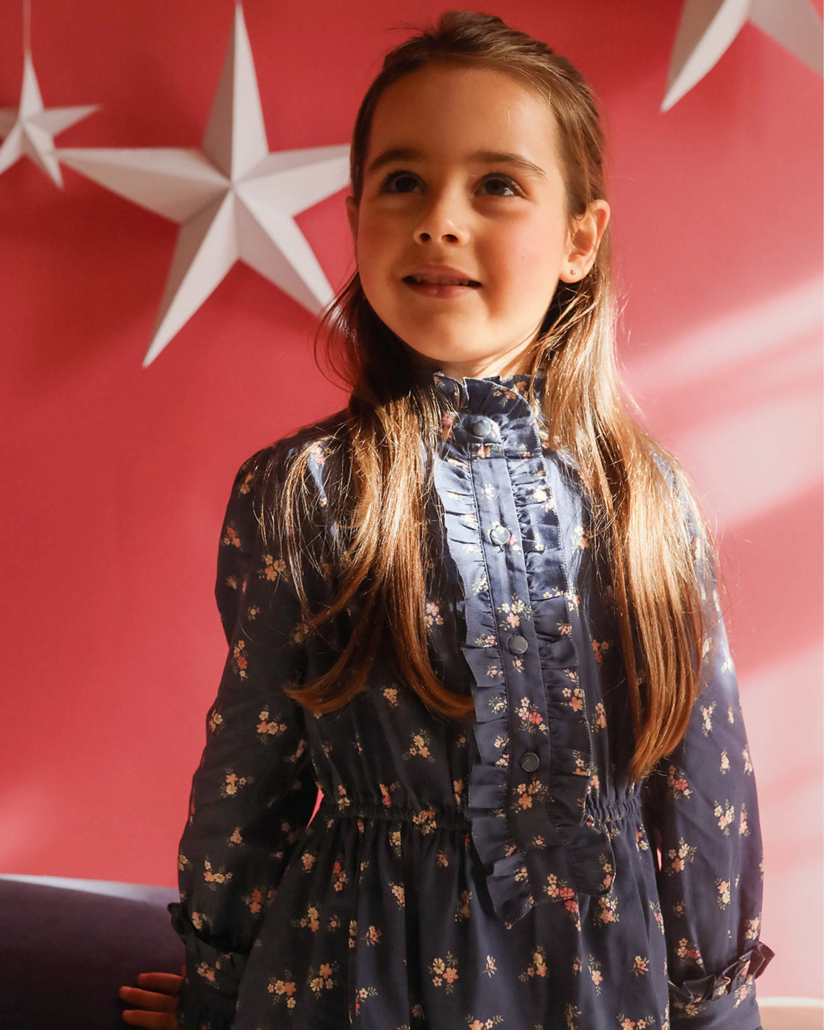 Early Sunday, Dawn Dress in Ditsy Bouquet Navy, made from Printed Cotton Satin fabric, featuring a soft flowing hem, shown in a close-up shot of a model wearing it during a studio shoot