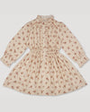 Early Sunday, Dawn Dress in Ditsy Bouquet Cream print, made from Printed Viscose Rayon Twill fabric, featuring Collar and sleeve cuffs trimmed with subtle ruffles for a nostalgic silhouette, shown in a front flat-lay view