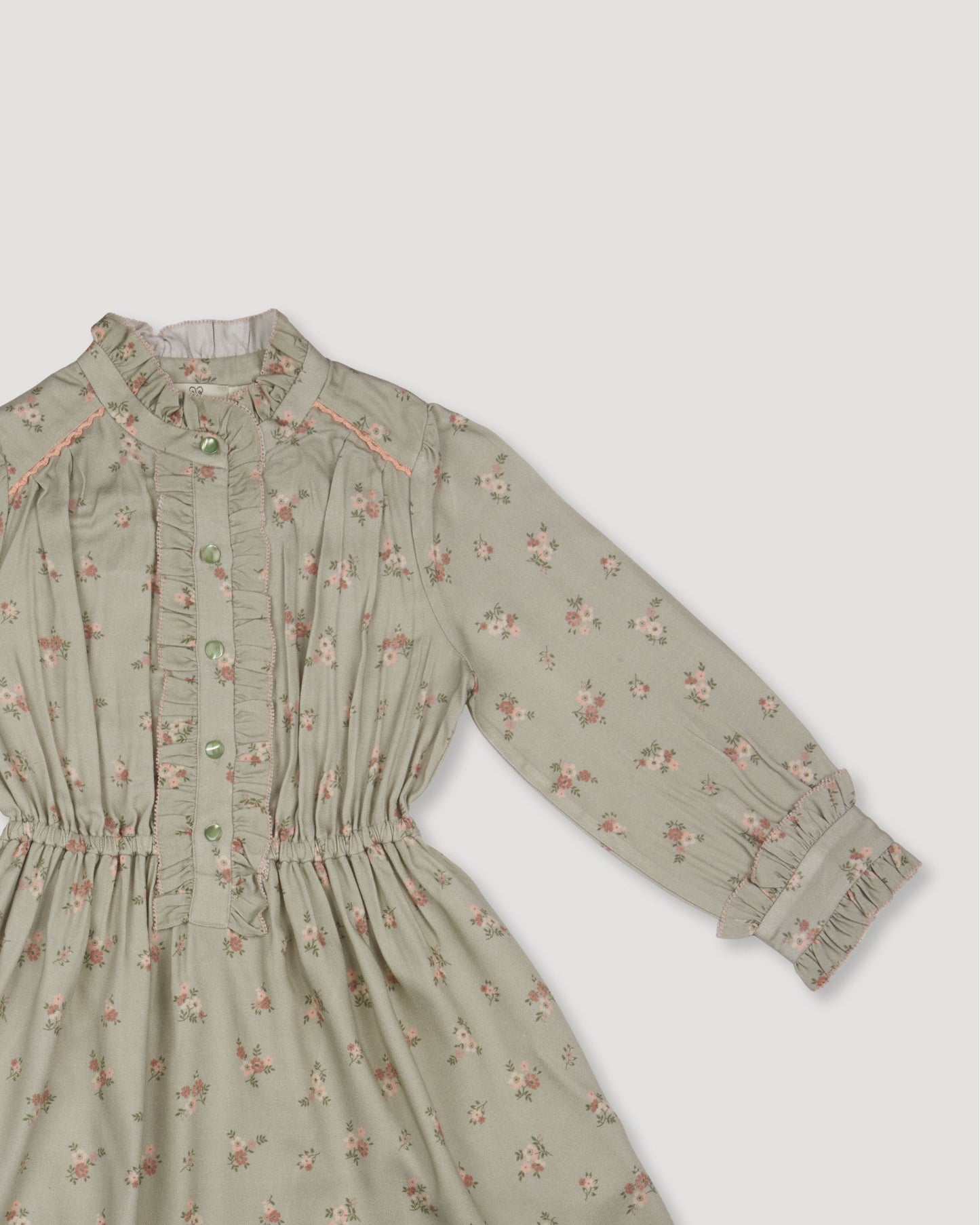 Early Sunday, Dawn Dress in Ditsy Bouquet Jade print, made from Printed Viscose Rayon Twill fabric, featuring Collar and sleeve cuffs trimmed with subtle ruffles for a nostalgic silhouette, shown in a closeup flat-lay view