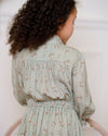 Early Sunday, Dawn Dress in Ditsy Bouquet Jade print, made from Printed Viscose Rayon Twill fabric, featuring Collar and sleeve cuffs trimmed with subtle ruffles for a nostalgic silhouette, shown in a back view of model wearing it