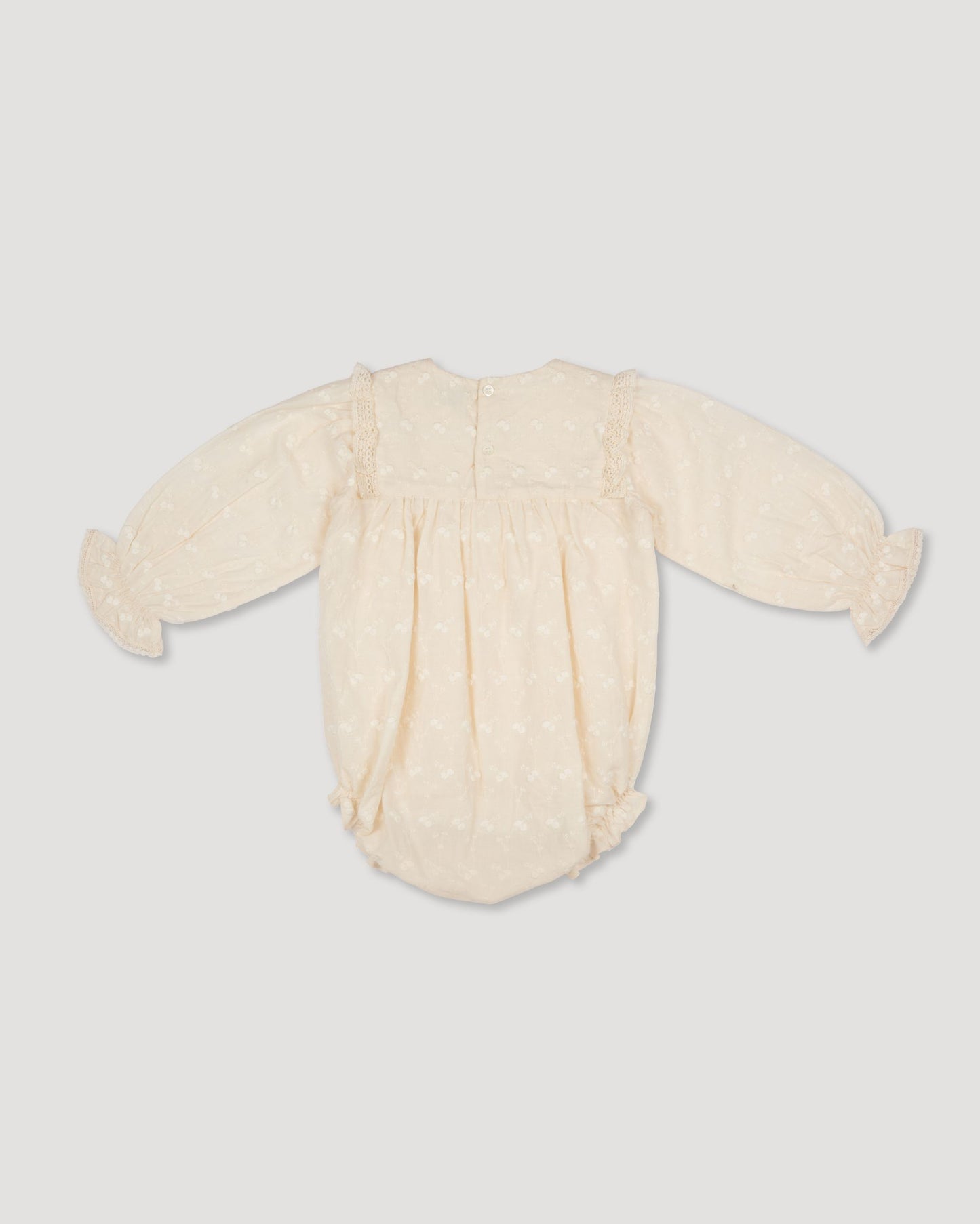 Early Sunday, Dolly Baby Bubble Romper in Hazelnut Cream color, made from All-over Embroidered Cotton Cambric fabric, featuring smocked sleeves & a square lace yoke, shown in a back flat-lay view