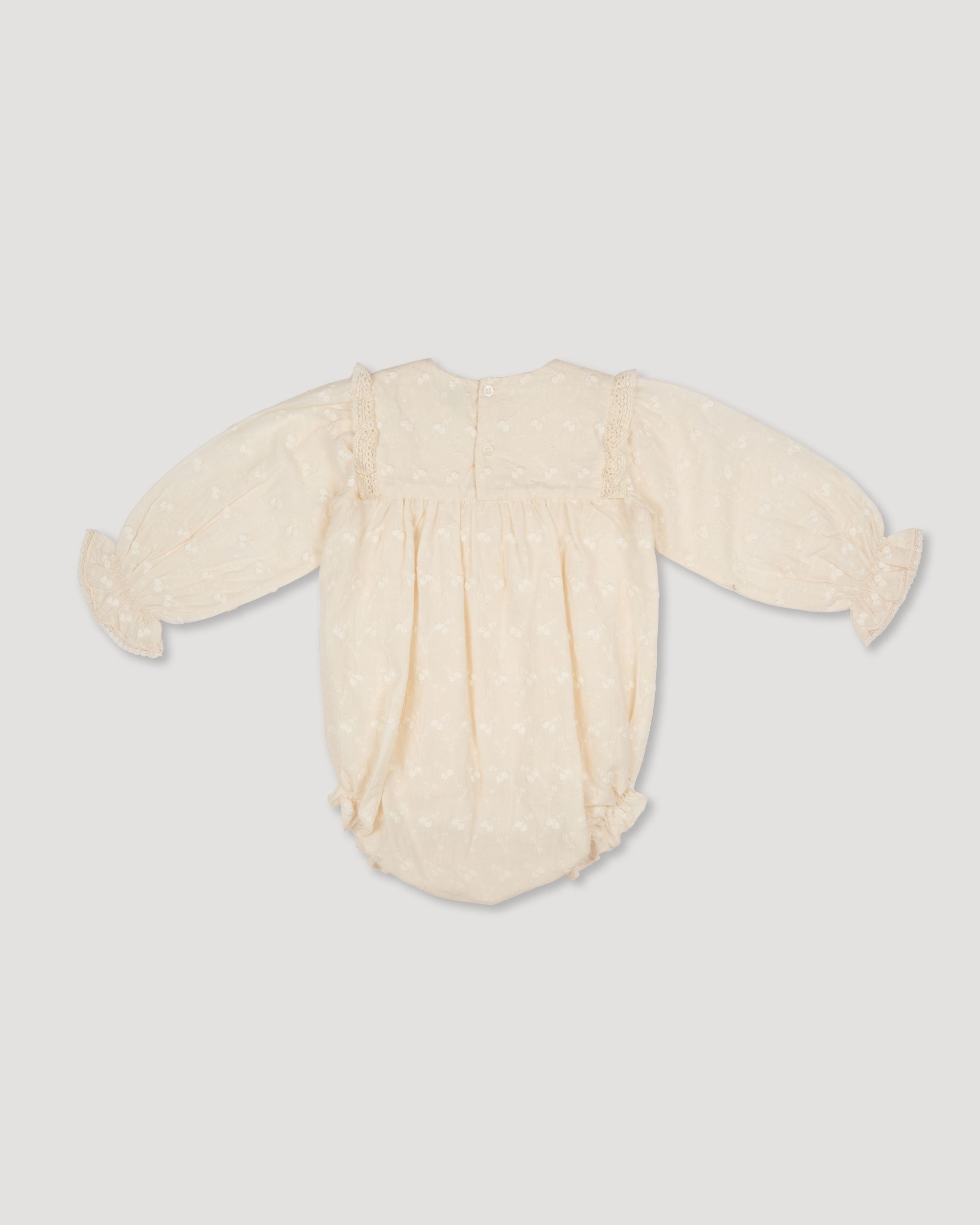 Early Sunday, Dolly Baby Bubble Romper in Hazelnut Cream color, made from All-over Embroidered Cotton Cambric fabric, featuring smocked sleeves & a square lace yoke, shown in a back flat-lay view