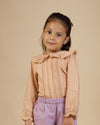 Early Sunday, Ella Blouse in Nude, made from Cotton Cambric fabric, featuring relaxed fit, frill detailing on the collar, and lace inserts, shown in a close-up side view of a model wearing it
