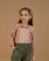 Early Sunday, Ella Blouse in Fawn Soft Pinkish Brown, made from Printed Cotton Cambric fabric, featuring relaxed fit, frill detailing on the collar, and lace inserts, shown in a close-up shot of a model wearing it during a studio shoot