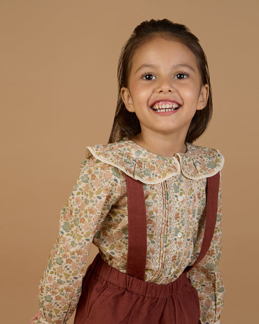 Early Sunday, Ella Blouse in Garden Flowers Cream, made from Printed Cotton Cambric fabric, featuring relaxed fit, frill detailing on the collar, and lace inserts, shown in a close-up side view of a model wearing it