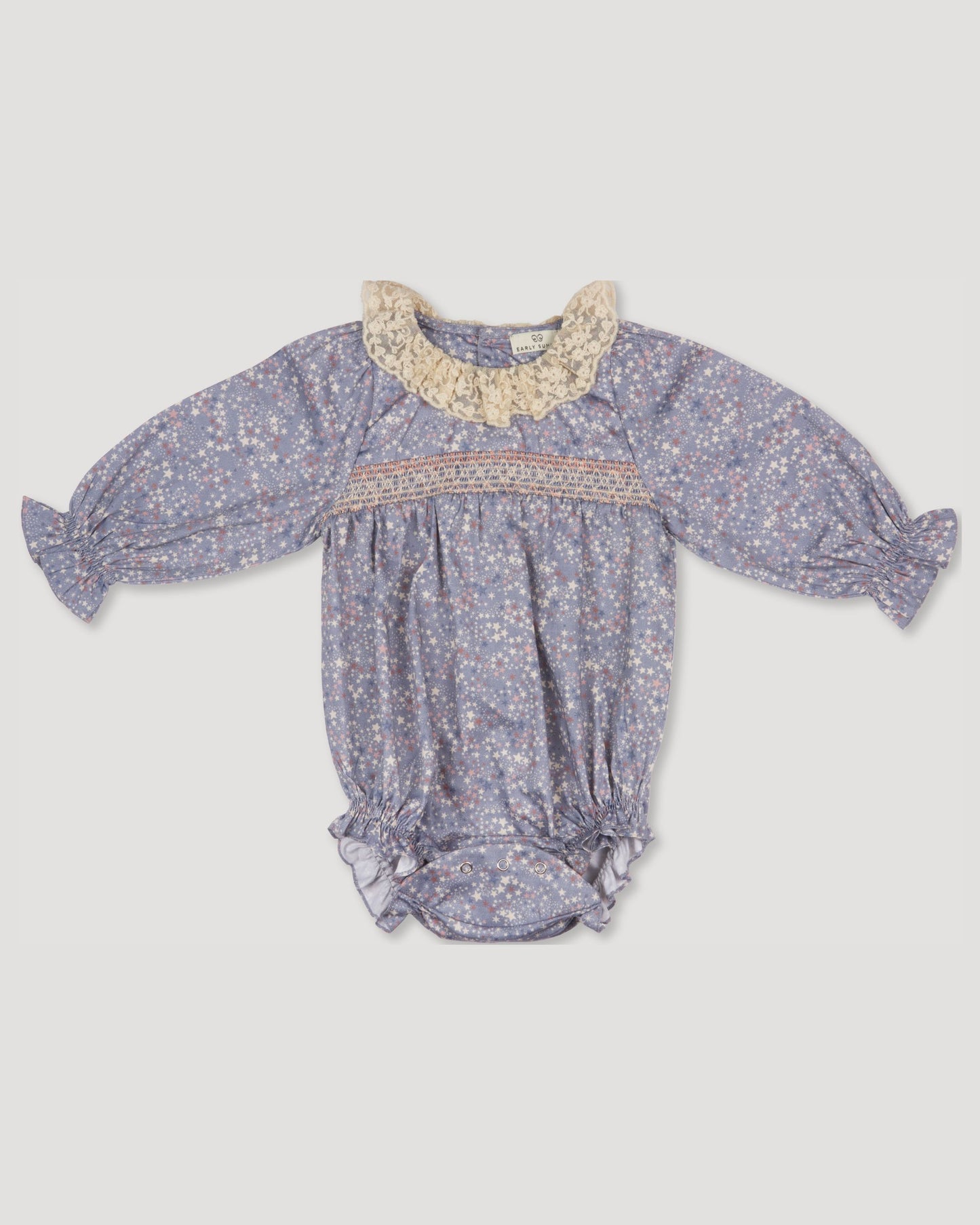 Early Sunday, Ellie Baby Bubble Romper in Celestial print, made from Printed 60s cotton satin fabric, featuring smocked sleeves with laced neckline, shown in a front flat-lay view