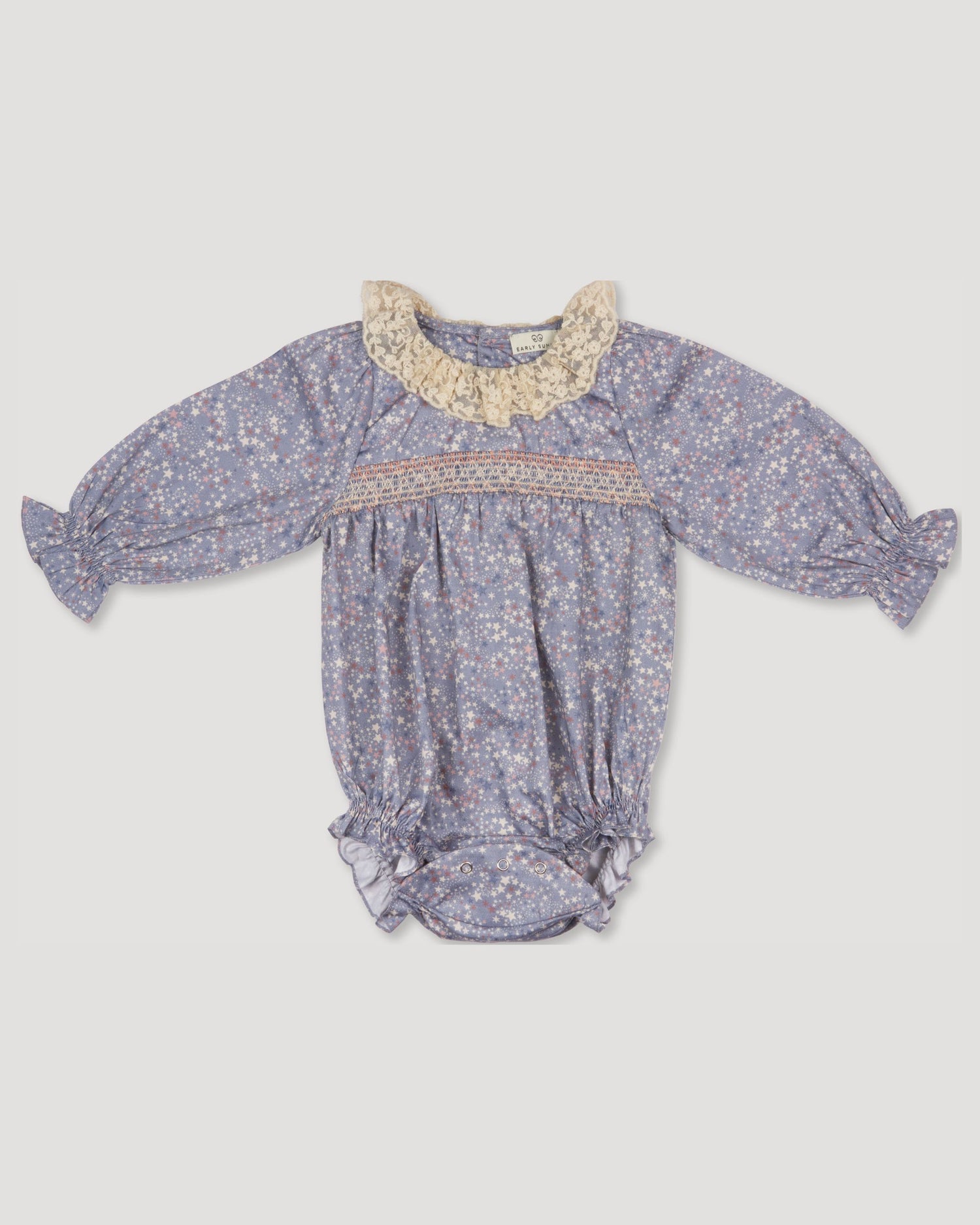 Early Sunday, Ellie Baby Bubble Romper in Celestial print, made from Printed 60s cotton satin fabric, featuring smocked sleeves with laced neckline, shown in a front flat-lay view