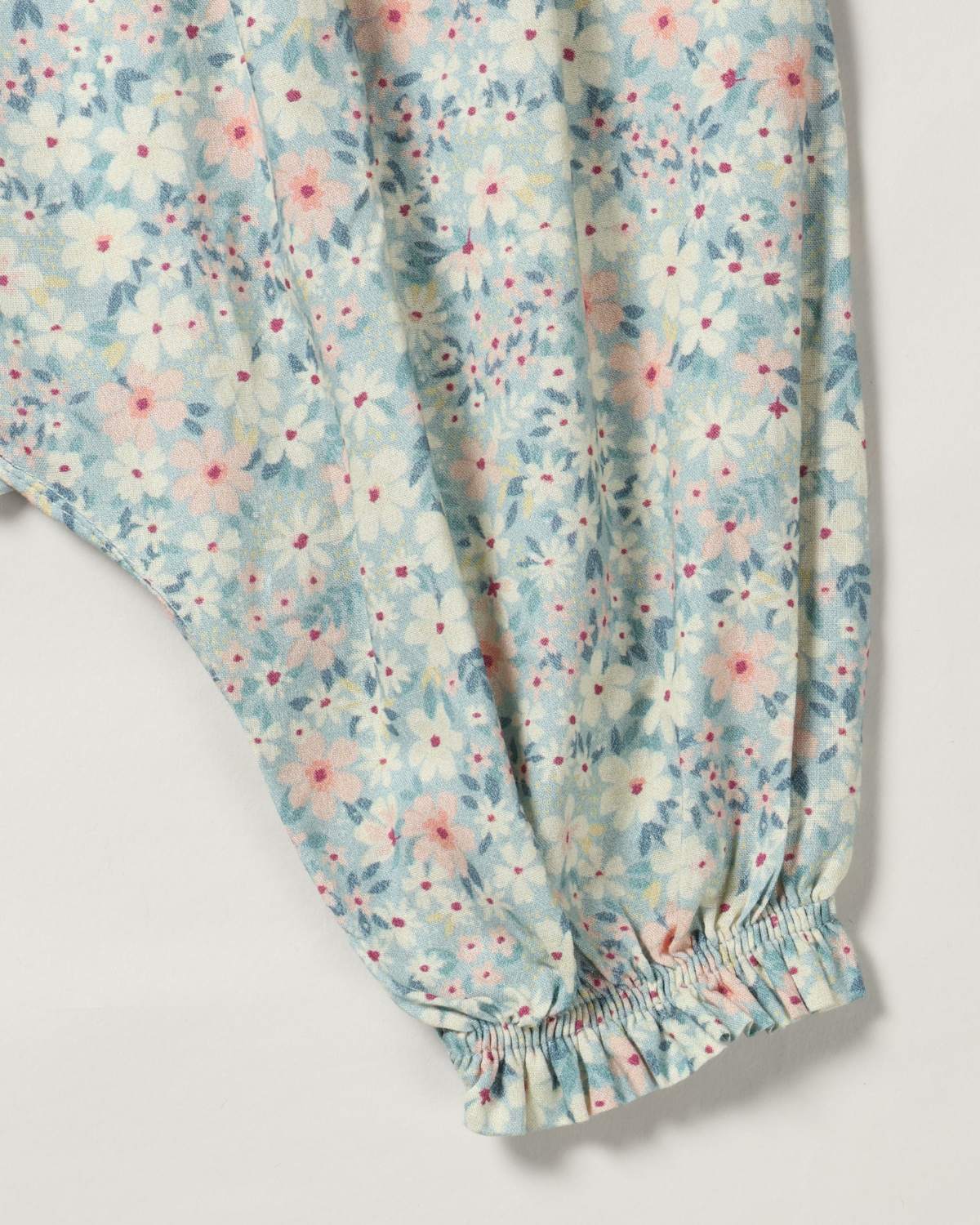 Early Sunday, Emma Baby Smocked Overalls Romper in Amelia print, made from Printed Cotton Cambric fabric, featuring a relaxed fit with smocked chest band & frilled sleeves, shown in a closeup flat-lay view