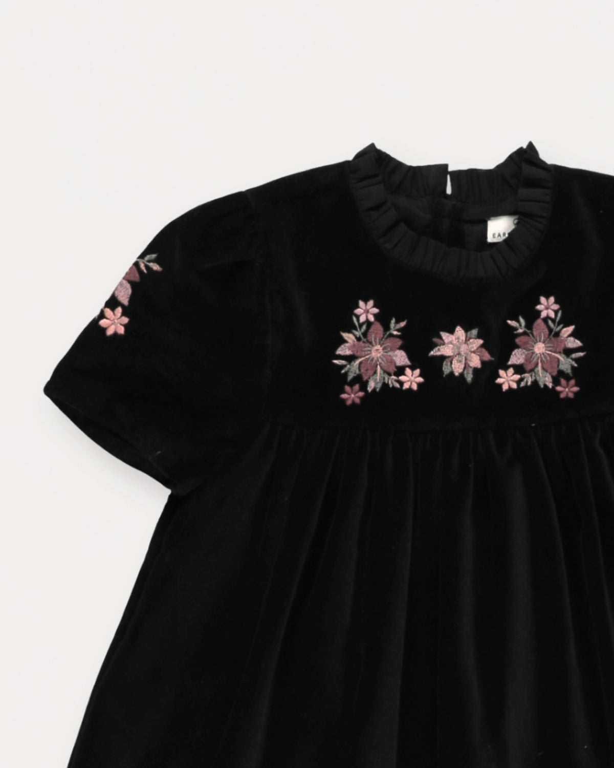 Early Sunday, Erika Dress in Black, made from Cotton Velvet Velour's fabric, featuring a beautiful embroidery with frilled neckline, shown in a closeup flat-lay view