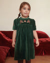 Early Sunday, Erika Dress in Forest Green, made from Cotton Velvet Velour's fabric, featuring a beautiful embroidery with frilled neckline, shown in a front view of model wearing it