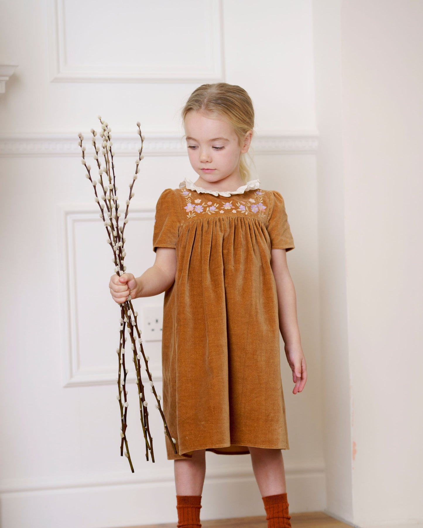 Early Sunday, Erika Dress in Almond, made from Dyed Cotton Velvet fabric, featuring Flowy A-line silhouette allows ease of movement and day-long comfort, shown in a front view of model wearing it