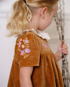Early Sunday, Erika Dress in Almond, made from Dyed Cotton Velvet fabric, featuring Flowy A-line silhouette allows ease of movement and day-long comfort, shown in a side view of model wearing it