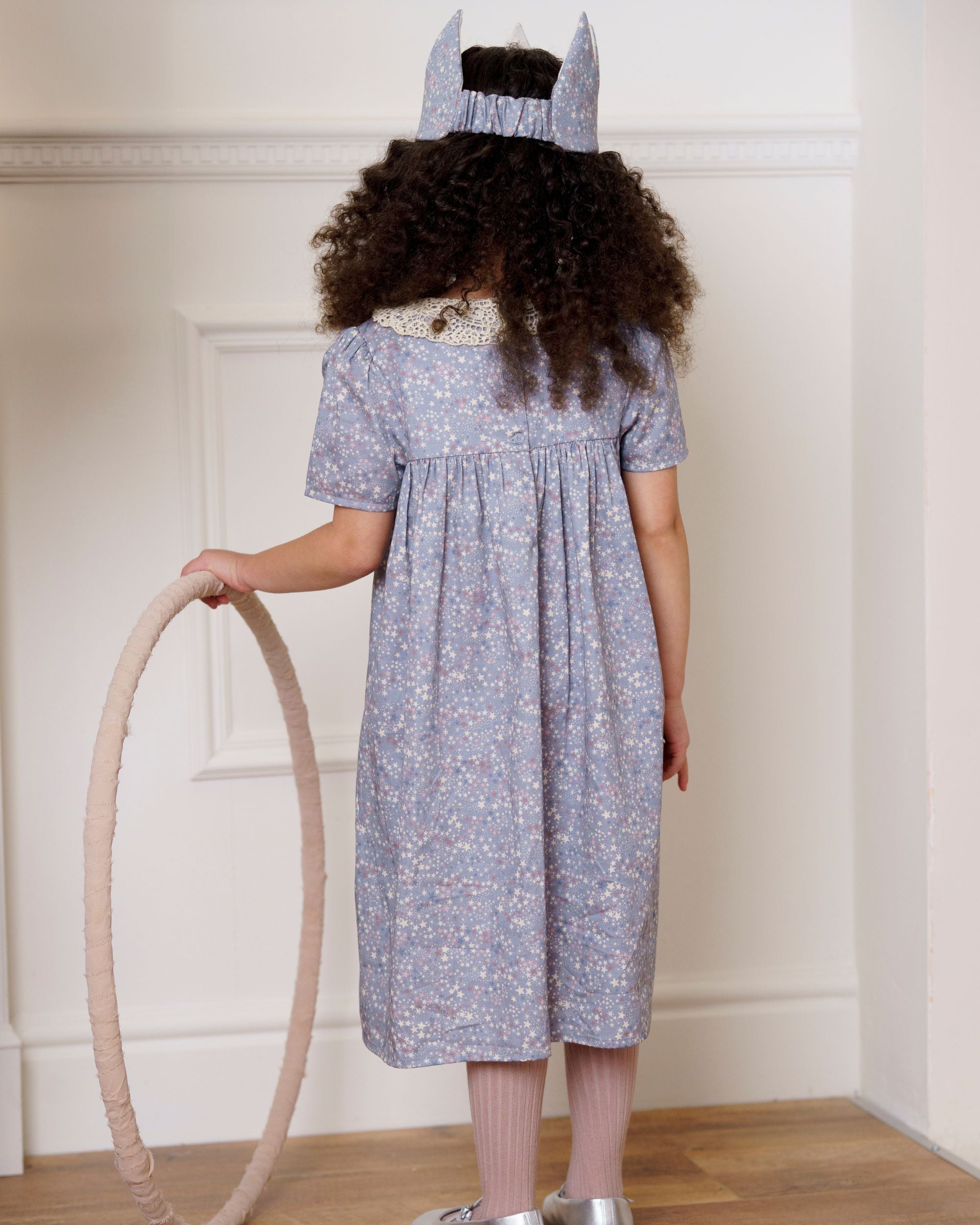 Early Sunday, Erika Dress in Celestial print, made from Printed Cotton Satin fabric, featuring Flowy A-line silhouette allows ease of movement and day-long comfort, shown in a back view of model wearing it