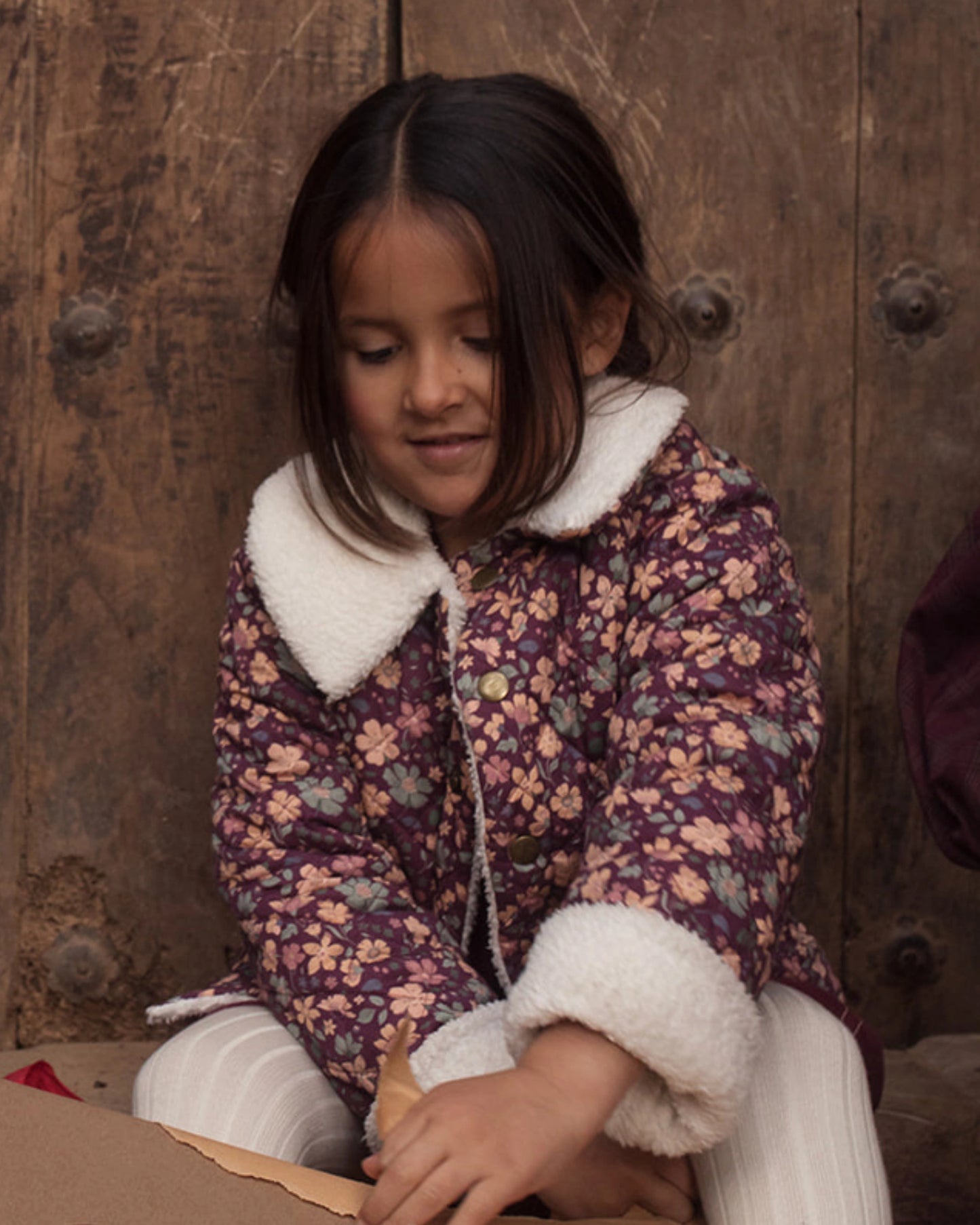 Early Sunday, Esmée Jacket in Garden Flowers Plum, made from Printed Cotton Satin fabric, featuring a quilted layer with delicate floral print and elegant detailing, shown in a front view of models playing outdoors