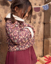 Early Sunday, Esmée Jacket in Garden Flowers Plum, made from Printed Cotton Satin fabric, featuring a quilted layer with delicate floral print and elegant detailing, shown in a side view of model wearing outdoors