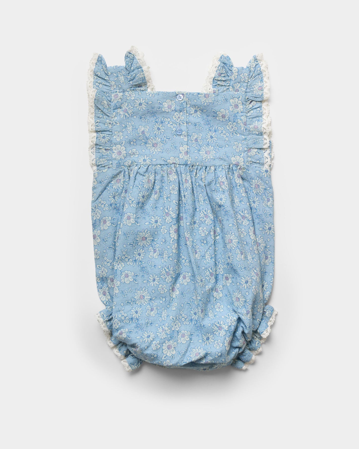 Early Sunday, Eva Baby Romper in Tonal Floral Blue color, made from 100% Cotton Swiss Dobby Tiny Dots fabric, featuring a sleeveless design with lace border, shown in a back flat-lay view