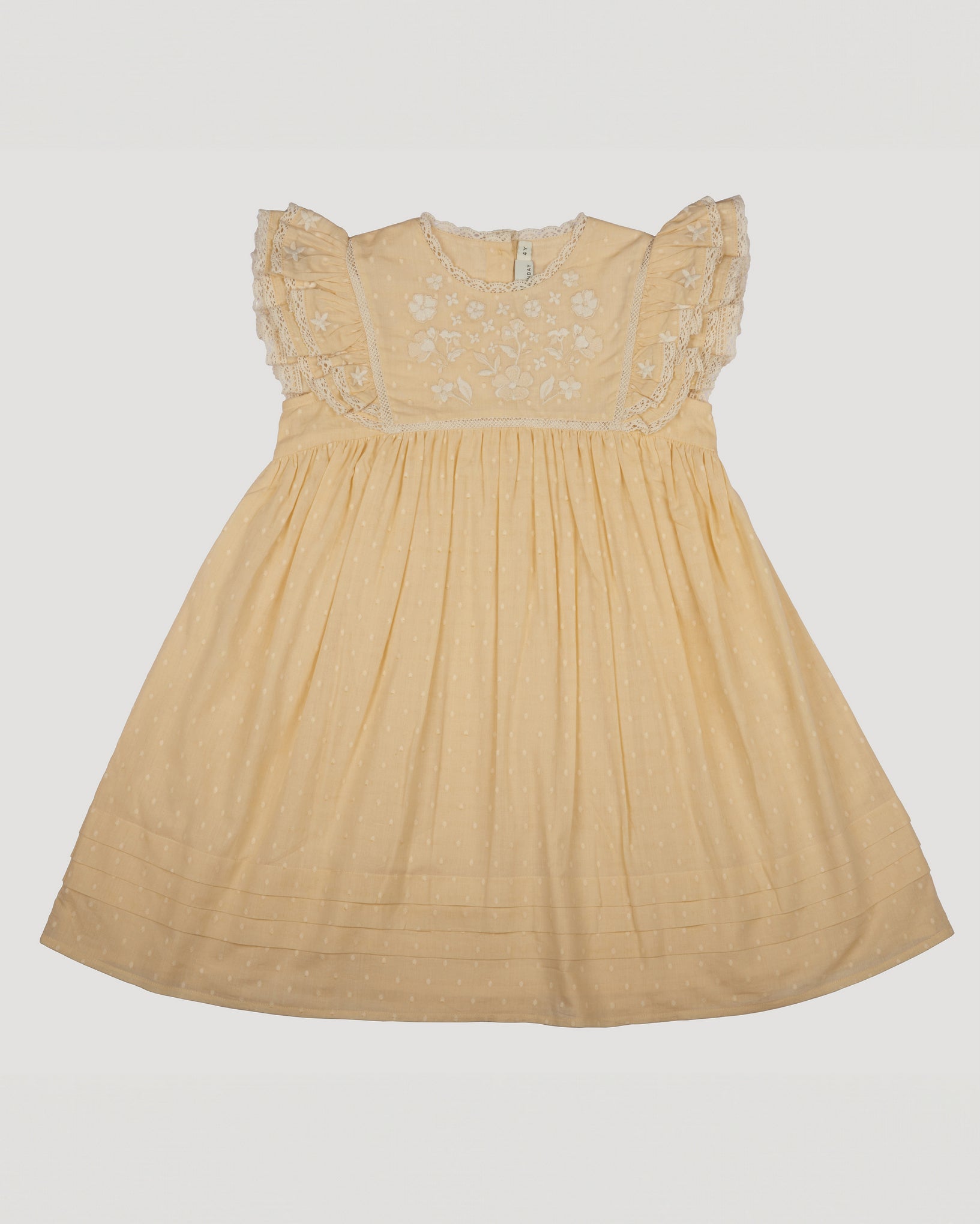 Early Sunday, Georgia Dress in Vanilla color, made from Cotton Dobby Swiss Dots fabric, featuring flutter sleeves, pintuck detailing, and a flowy, gathered silhouette, shown in a front flat-lay view