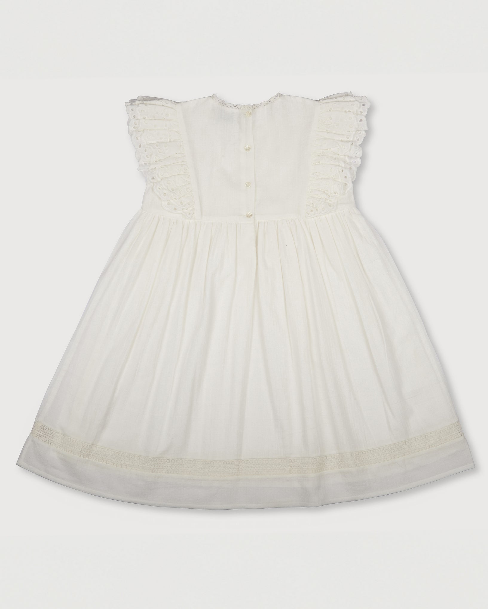 Early Sunday, Georgia Dress in Ivory print, made from Cotton Tiny Swiss Dots fabric, featuring Flutter sleeves, pintuck detailing, and a flowy, gathered silhouette, shown in a back flat-lay view