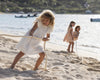 Early Sunday, Georgia Dress in Ivory color, made from Cotton Tiny Swiss Dots fabric, featuring flutter sleeves, pintuck detailing, and a flowy, gathered silhouette, shown in a front view of model wearing it