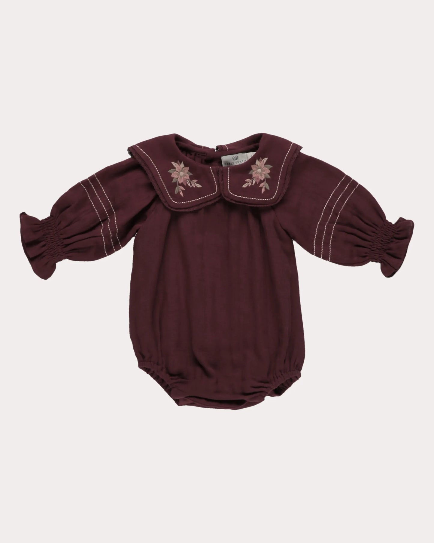 Early Sunday, Gladys Baby Bubble Romper in Plum, made from Cotton Double Gauze fabric, featuring a floral embroidered collar with beautiful lace yoke, shown in a front flat-lay view