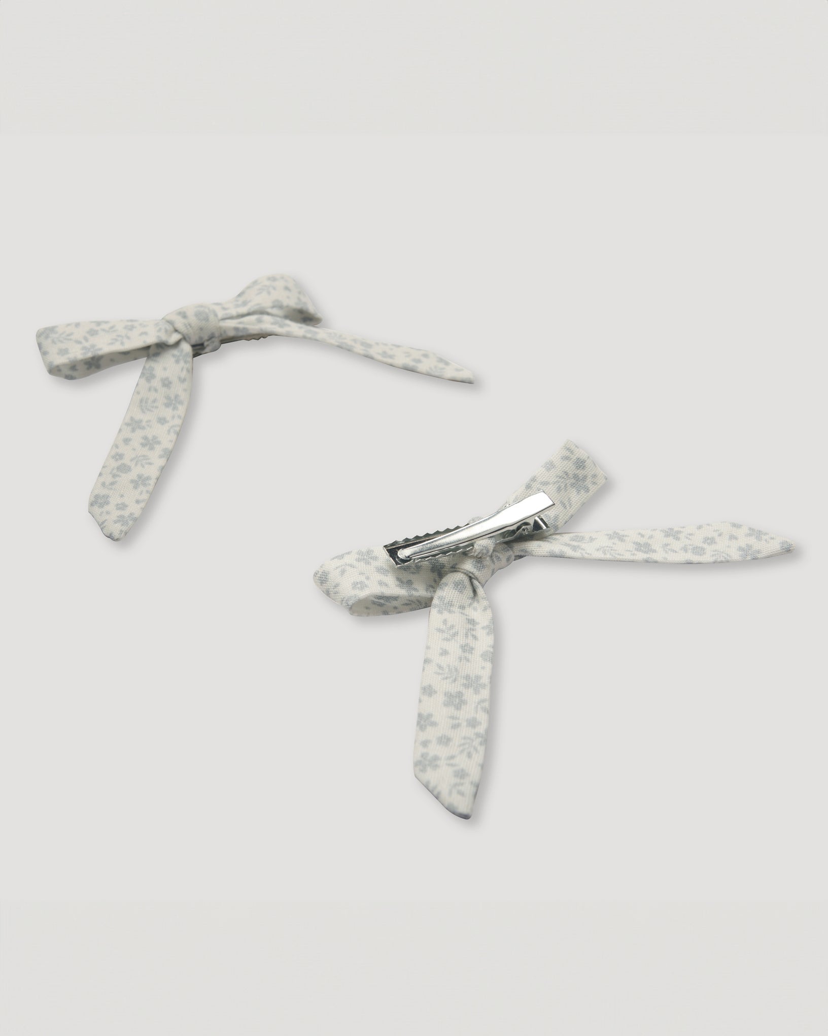 Early Sunday, Chiara Alligator Clip in Mini Flower print, made from Printed canvas 70% Cotton 30% Linen fabric, featuring a bow design on an alligator clip with a secure fit, shown in a back flat-lay view