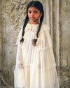 Early Sunday, Grace Cape in Hazelnut Cream, made from Dyed Nylon Mesh Dobby fabric, featuring Tiered ruffles create volume and whimsical movement, shown in a front view of a model wearing it in a studio setting