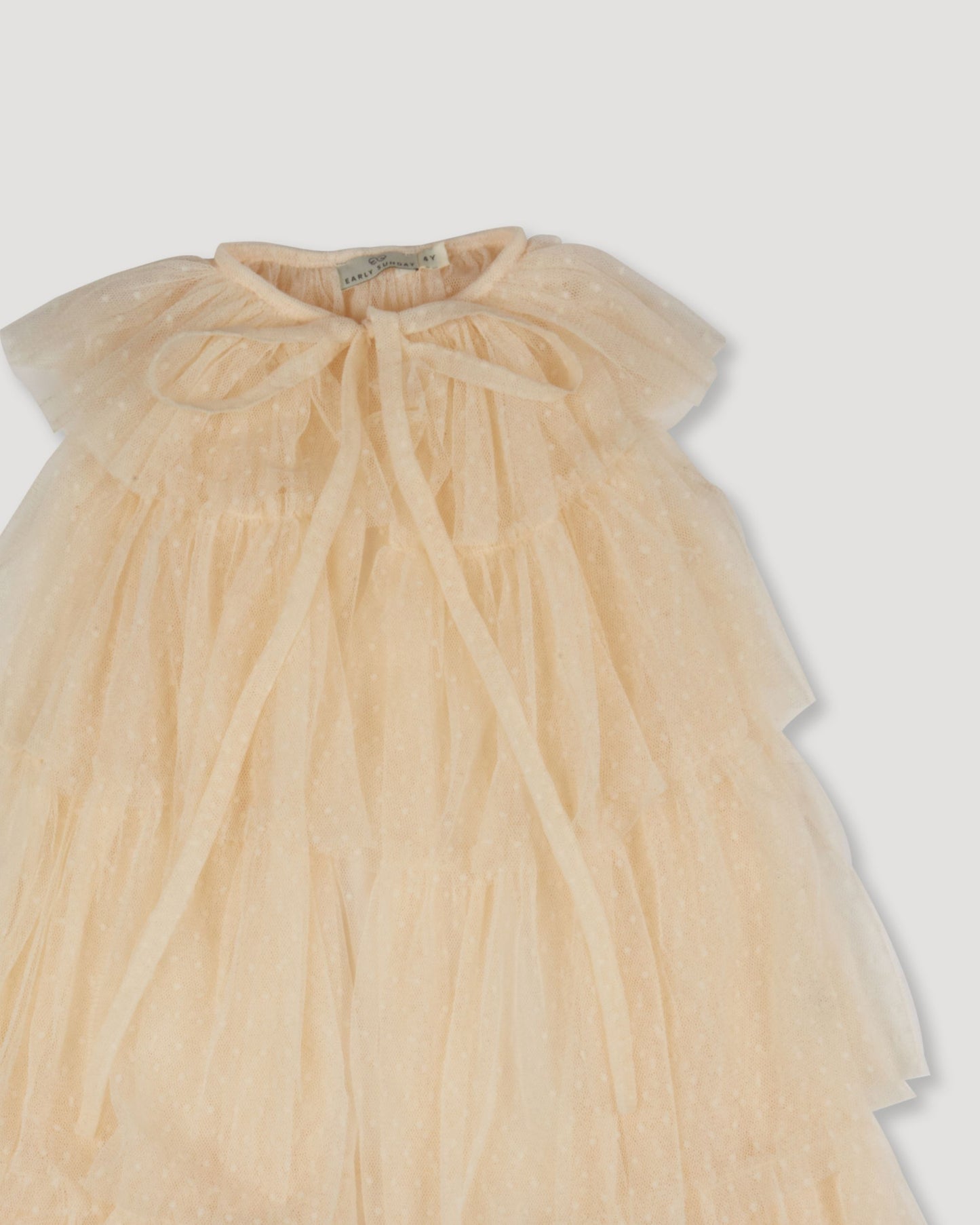 Early Sunday, Grace Cape in Hazelnut Cream, made from Dyed Nylon Mesh Dobby fabric, featuring Tiered ruffles create volume and whimsical movement, shown in a closeup flat-lay view