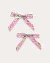 Early Sunday, Grace Clip in Emma Floral Purple color, made from Organic Printed Cotton Cambric fabric, featuring a set of two bow clips with a secure fit, shown in back flat-lay view