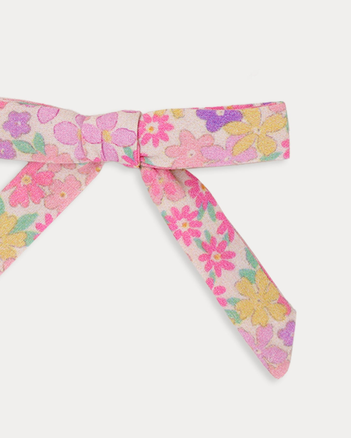 Early Sunday, Grace Clip in Emma Floral Purple color, made from Organic Printed Cotton Cambric fabric, featuring a set of two bow clips with a secure fit, shown in closeup flat-lay view