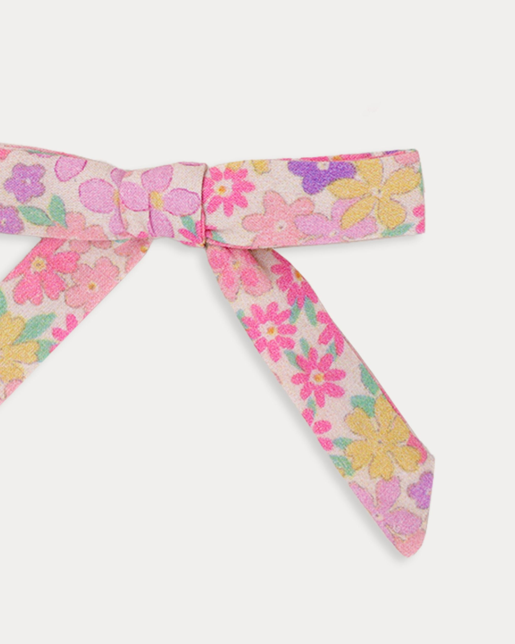 Early Sunday, Grace Clip in Emma Floral Purple color, made from Organic Printed Cotton Cambric fabric, featuring a set of two bow clips with a secure fit, shown in closeup flat-lay view