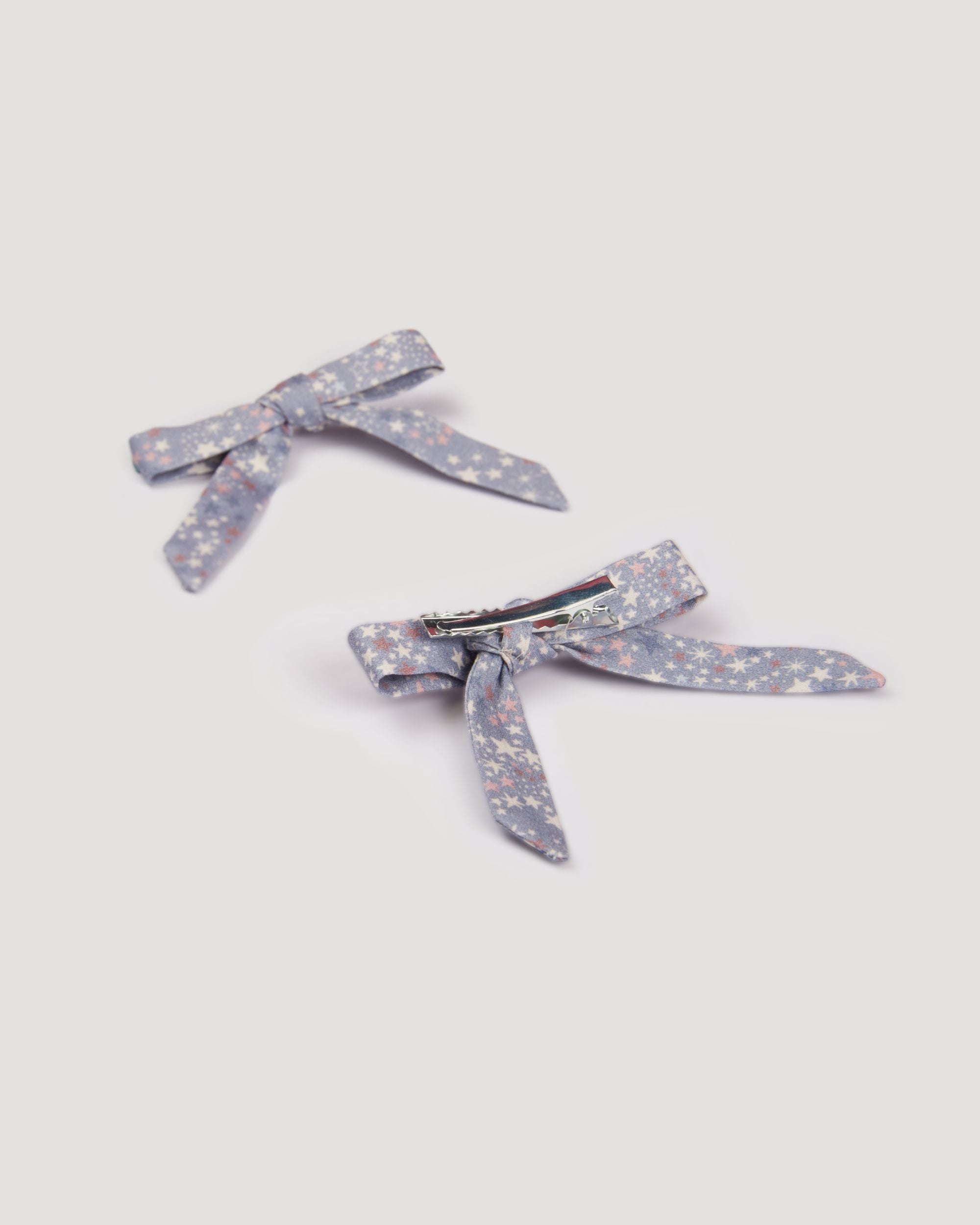 Early Sunday, Grace Clip in Celestial print, made from Printed 60s Cotton Satin fabric, featuring a set of two bow clips with a secure fit, shown in a back flat-lay view