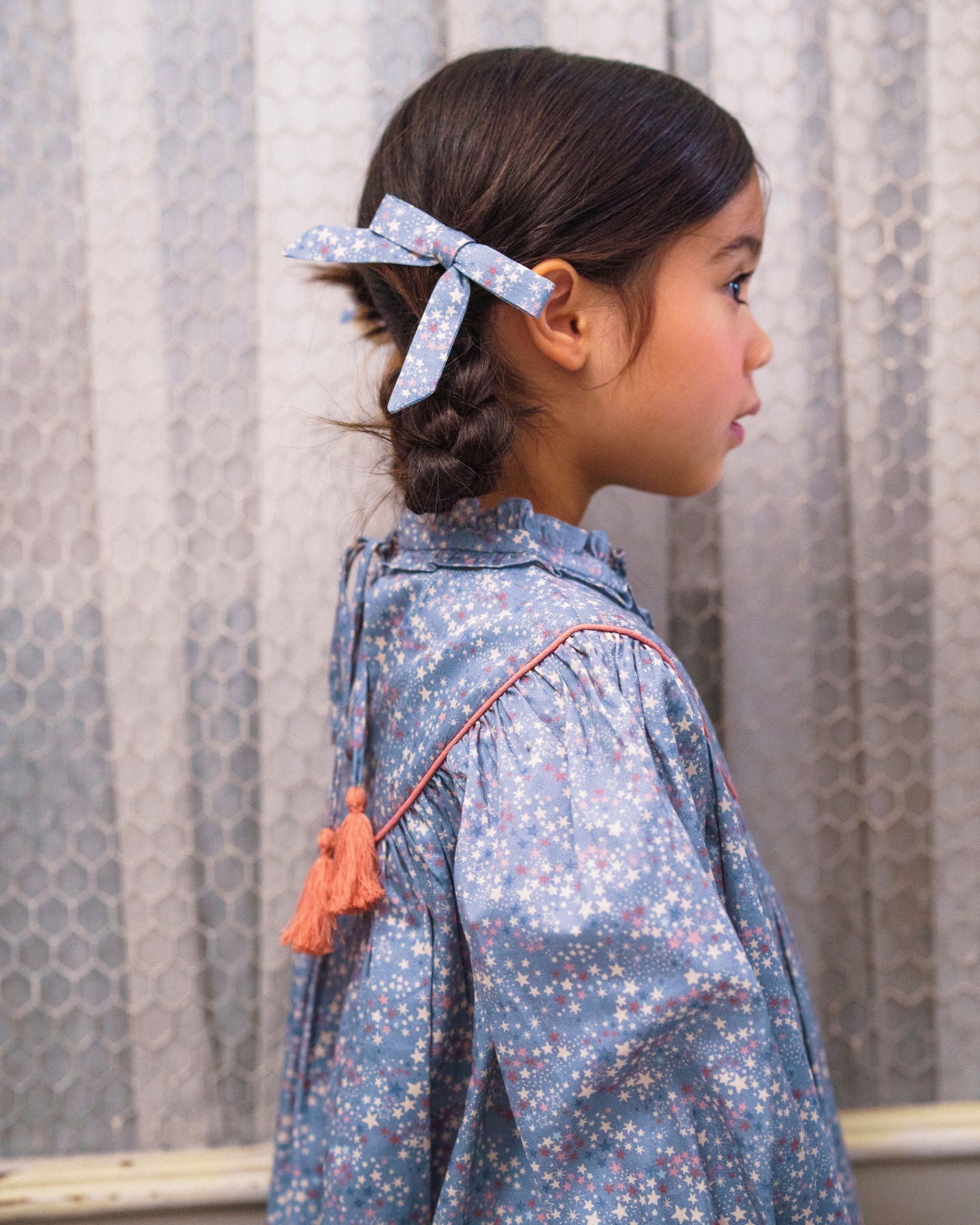 Early Sunday, Grace Clip in Celestial print, made from Printed 60s Cotton Satin fabric, featuring a set of two bow clips with a secure fit, shown in a close-up side view of a model wearing it