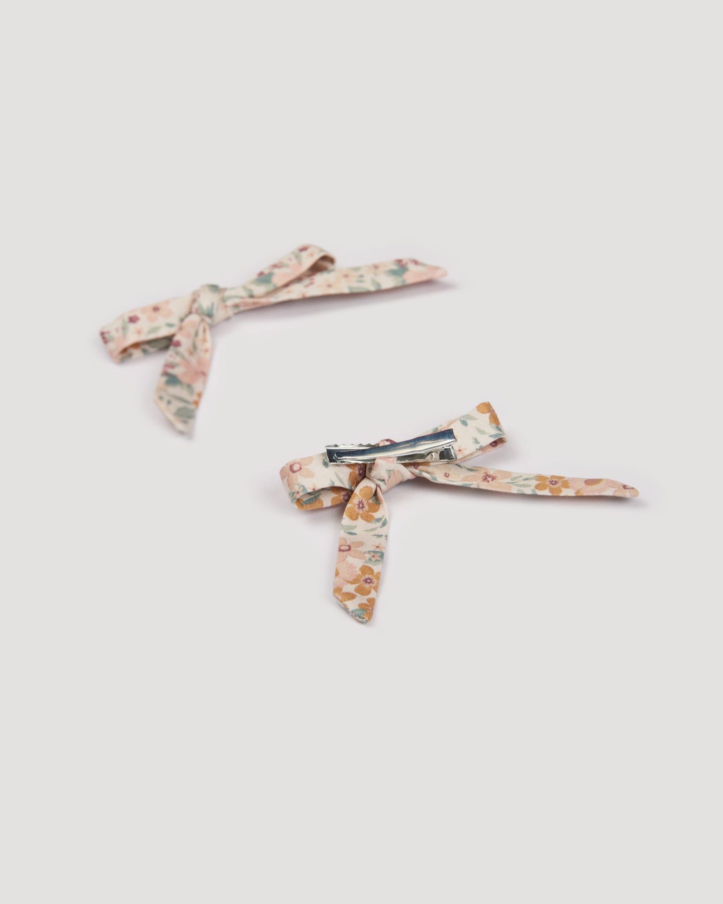 Early Sunday, Grace Clip in Floral print, made from Printed 60s Cotton Satin fabric, featuring a set of two bow clips with a secure fit, shown in a back flat-lay view