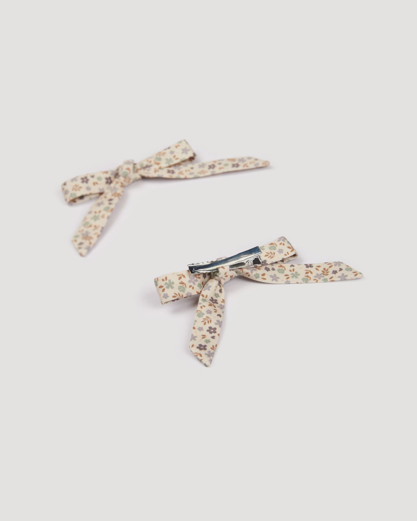 Early Sunday, Grace Clip in Mini Flowers print, made from Printed 60s Cotton Satin fabric, featuring a set of two bow clips with a secure fit, shown in a back flat-lay view