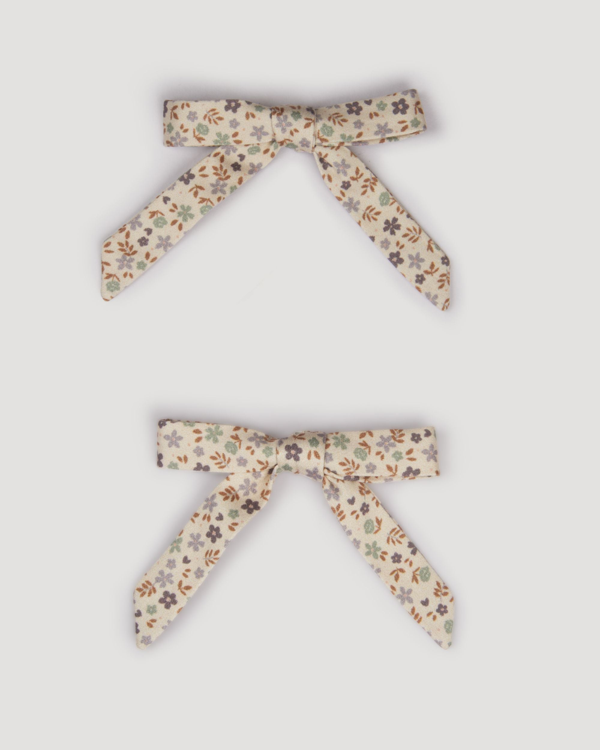 Early Sunday, Grace Clip in Mini Flowers print, made from Printed 60s Cotton Satin fabric, featuring a set of two bow clips with a secure fit, shown in a front flat-lay view